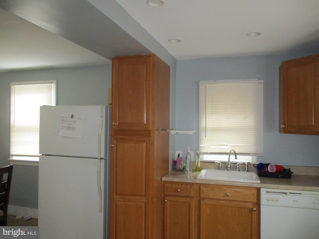 kitchen featuring white appliances and sink