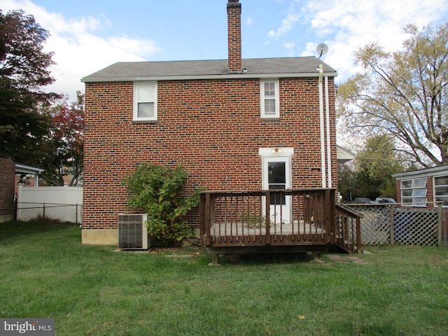 rear view of property with a wooden deck, a yard, and central air condition unit