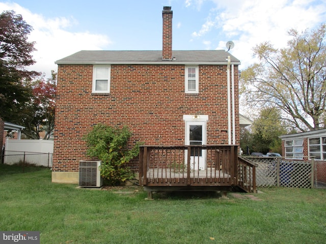 rear view of property with a yard, a deck, and central air condition unit