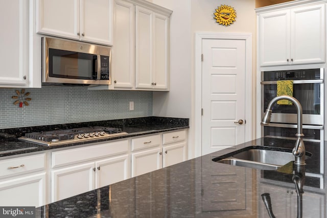 kitchen with white cabinets, dark stone counters, and appliances with stainless steel finishes