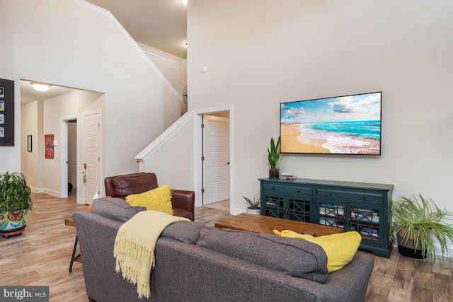 living room featuring a towering ceiling and wood-type flooring