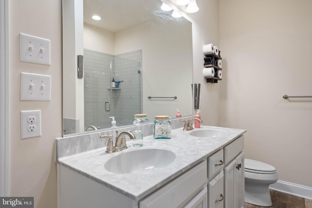 bathroom featuring vanity, toilet, and a shower with door