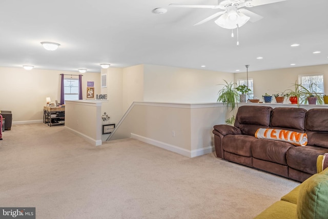 living room featuring light colored carpet, plenty of natural light, and ceiling fan