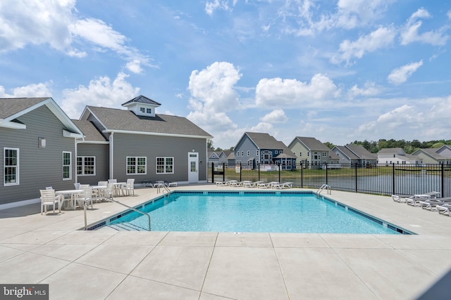 view of pool with a patio area and a water view