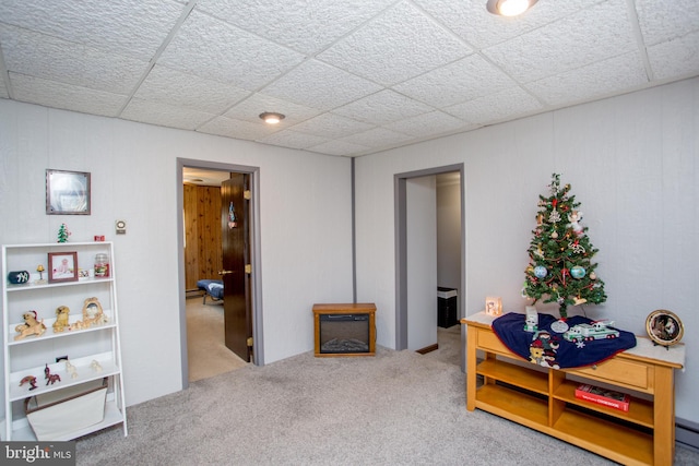 interior space featuring carpet flooring, a baseboard heating unit, and a drop ceiling