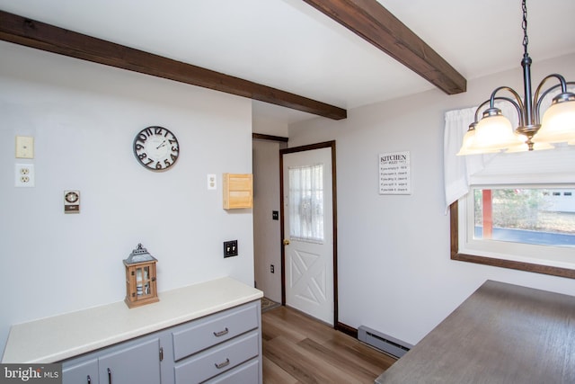 interior space featuring a baseboard heating unit, an inviting chandelier, beamed ceiling, and wood finished floors
