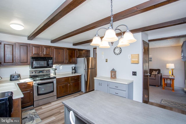 kitchen with light wood-style flooring, stainless steel appliances, light countertops, pendant lighting, and beamed ceiling