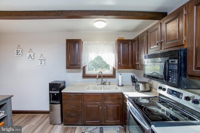 kitchen with black microwave, light countertops, beam ceiling, stainless steel range with electric stovetop, and a sink