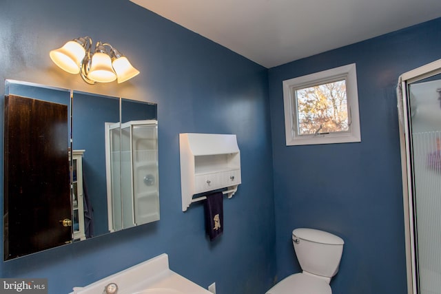 bathroom with a shower with door and toilet
