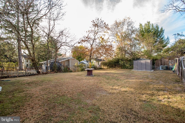 view of yard with an outbuilding, a storage unit, and a fenced backyard