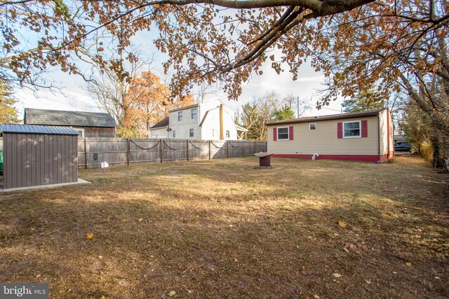 view of yard featuring an outbuilding, a storage unit, and a fenced backyard