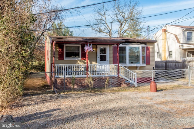 view of front of house featuring fence and covered porch