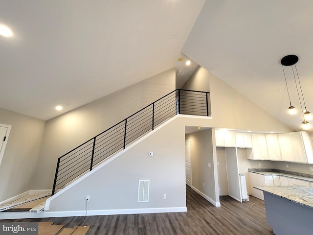 staircase featuring hardwood / wood-style floors and high vaulted ceiling