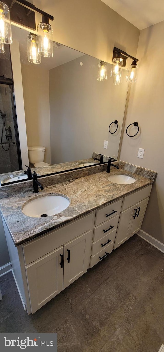 bathroom with vanity, toilet, and an enclosed shower