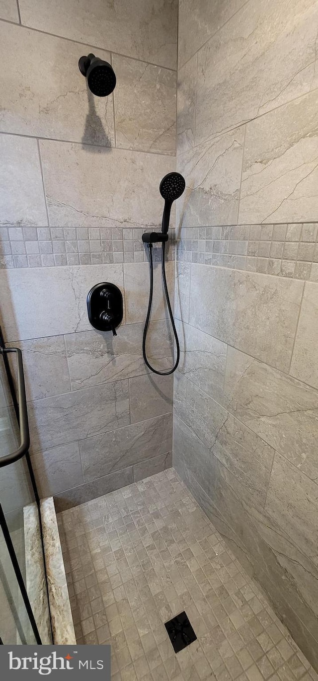 interior details featuring a tile shower