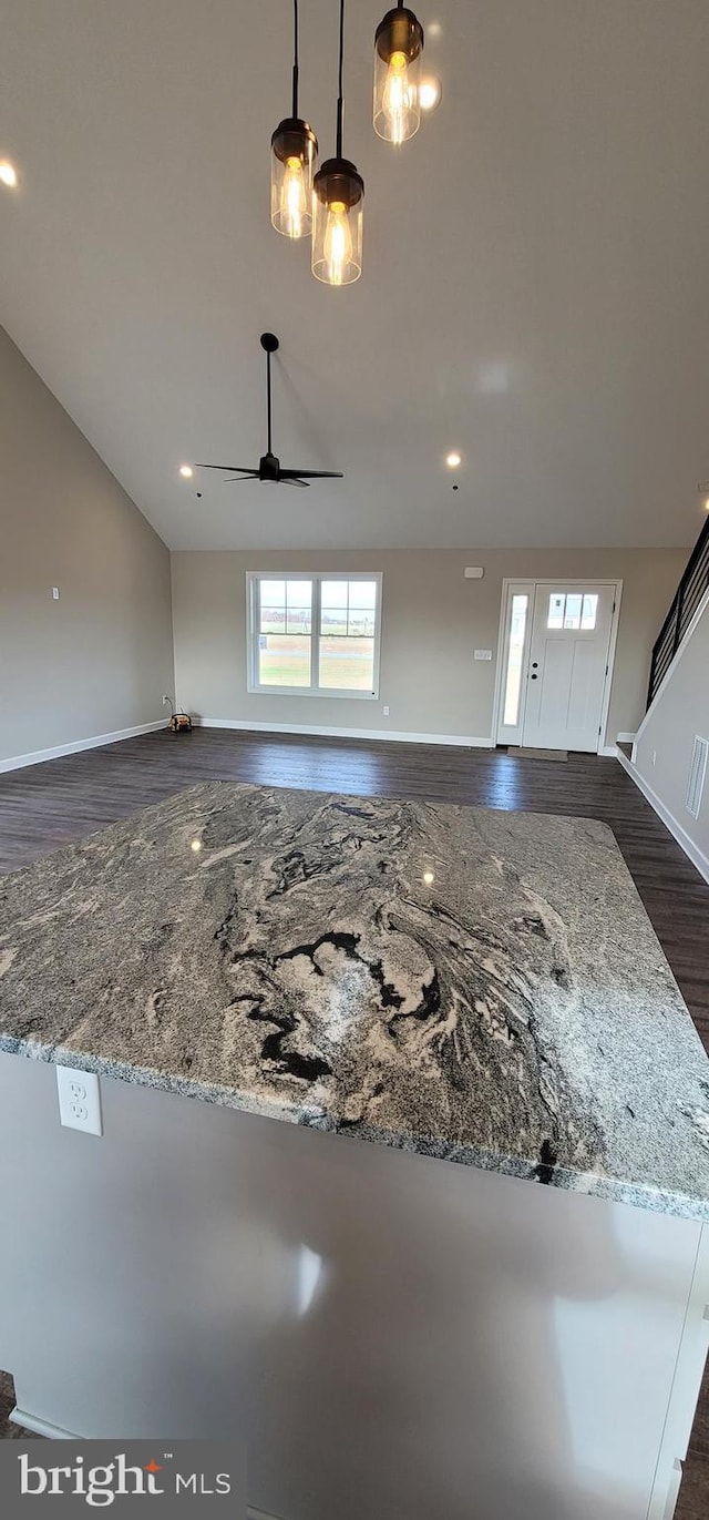 unfurnished living room featuring ceiling fan and dark hardwood / wood-style flooring