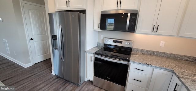 kitchen featuring light stone counters, stainless steel appliances, dark wood-type flooring, and white cabinets