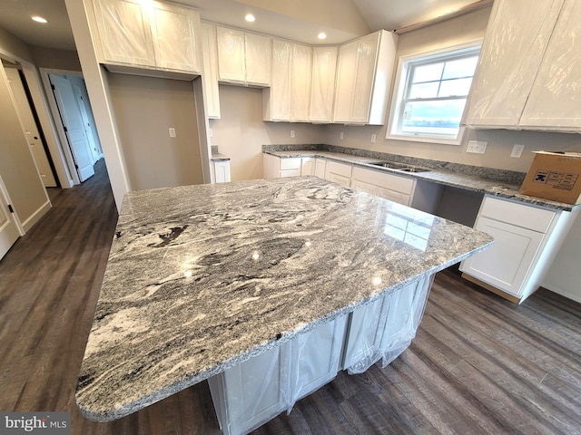 kitchen with white cabinetry, a center island, and dark hardwood / wood-style floors