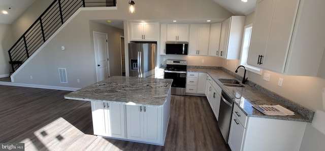 kitchen featuring stainless steel appliances, sink, a kitchen island, and white cabinets