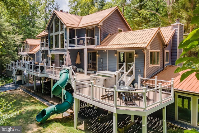 rear view of house with a playground and a wooden deck