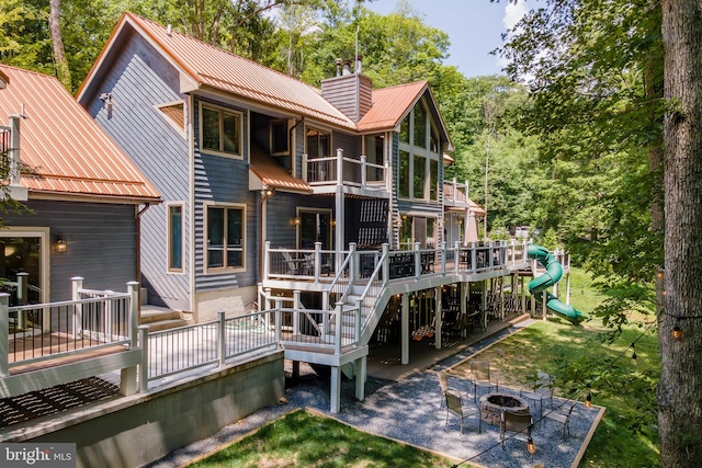 rear view of house featuring a deck and an outdoor fire pit