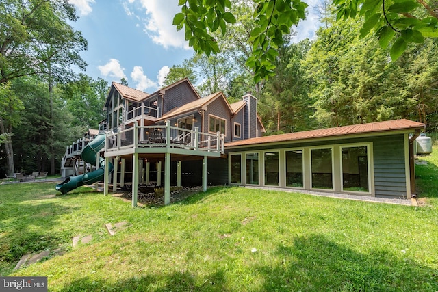 rear view of house with a lawn and a deck