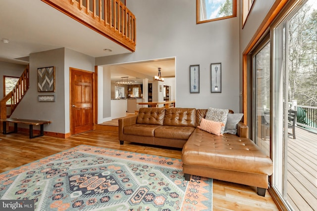 living room with light hardwood / wood-style floors, a healthy amount of sunlight, and a chandelier