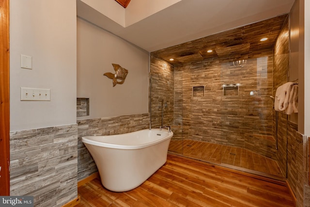 bathroom with separate shower and tub, hardwood / wood-style floors, and tile walls