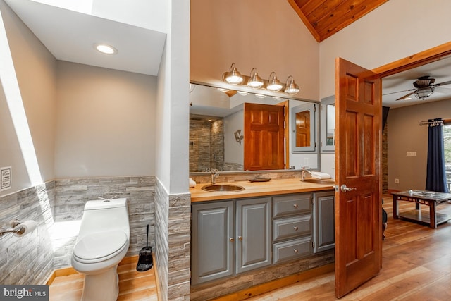 bathroom featuring ceiling fan, hardwood / wood-style floors, vaulted ceiling, toilet, and vanity