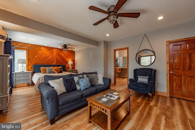 interior space with ceiling fan, wood walls, and light wood-type flooring