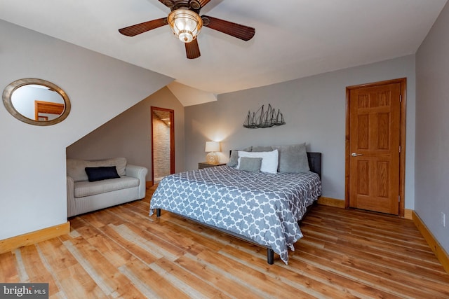 bedroom featuring ceiling fan, light hardwood / wood-style flooring, and lofted ceiling