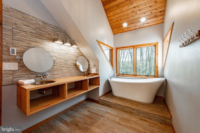 bathroom featuring a tub, vanity, hardwood / wood-style flooring, wooden ceiling, and lofted ceiling