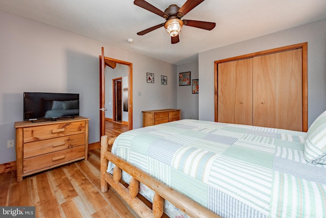 bedroom with light hardwood / wood-style floors, a closet, and ceiling fan