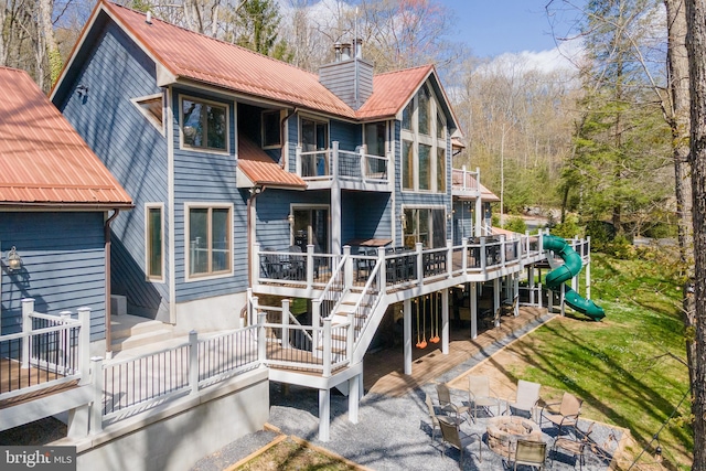 back of property featuring a patio area and a deck