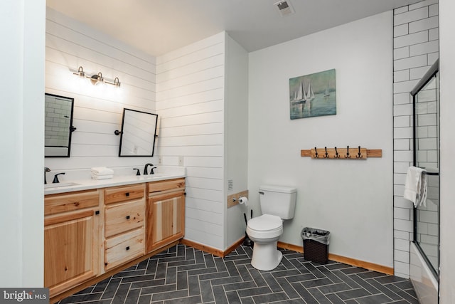 full bathroom featuring wood walls, vanity, enclosed tub / shower combo, and toilet