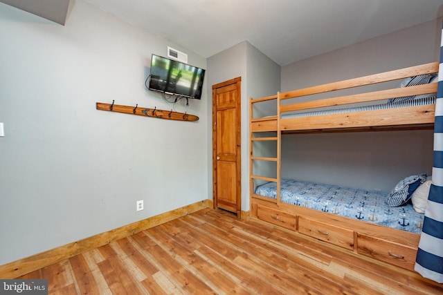 unfurnished bedroom with a closet and hardwood / wood-style flooring