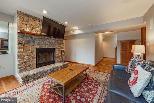 living room with light wood-type flooring and a fireplace