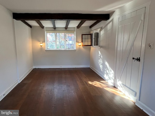 unfurnished room with beamed ceiling and dark hardwood / wood-style flooring