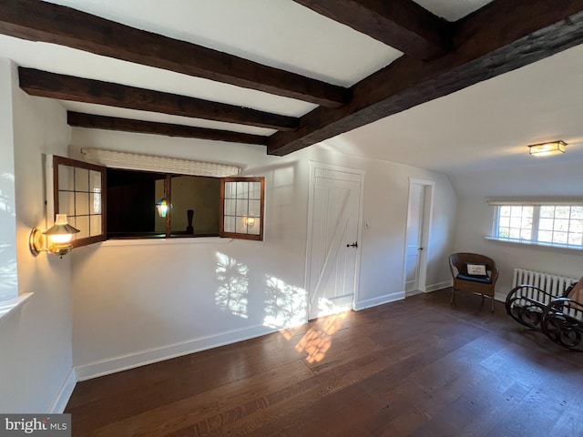 spare room featuring dark hardwood / wood-style floors and beamed ceiling