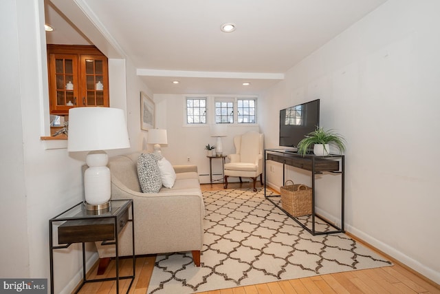 sitting room featuring a baseboard heating unit and light wood-type flooring