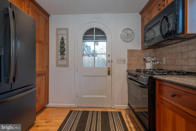 kitchen with tasteful backsplash, light hardwood / wood-style flooring, and black appliances