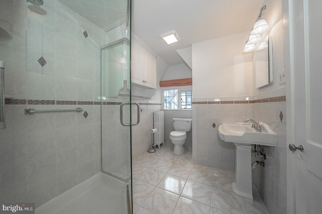 bathroom with an enclosed shower, toilet, radiator, and tile walls