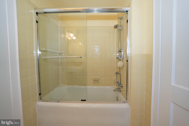 bathroom with bath / shower combo with glass door