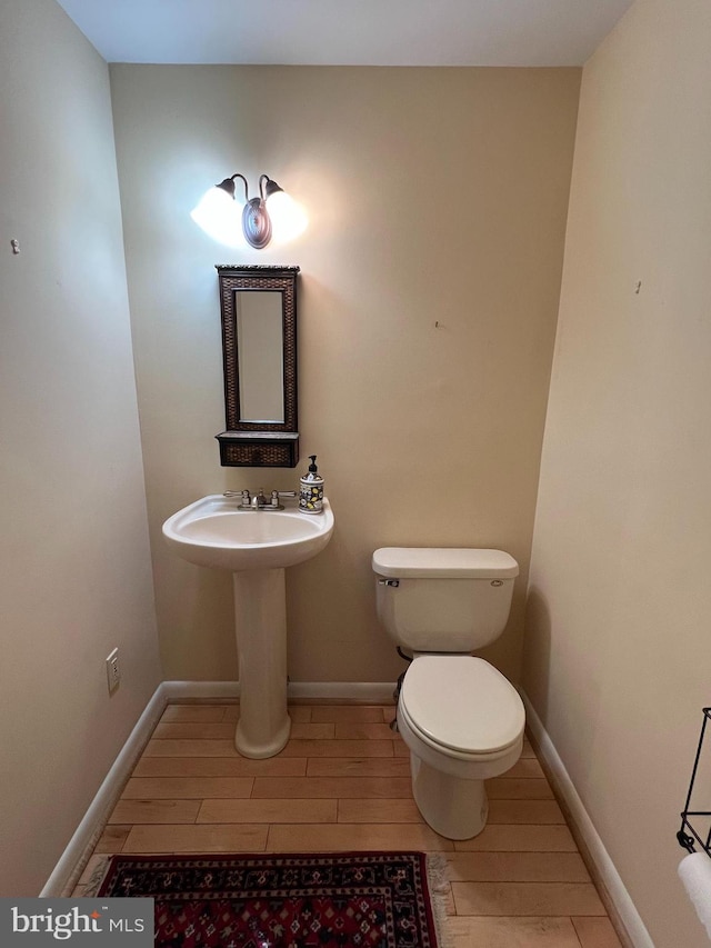 bathroom with wood-type flooring and toilet