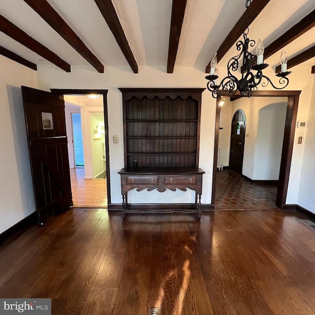 unfurnished living room with dark hardwood / wood-style floors and beamed ceiling