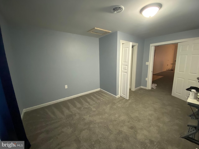 unfurnished bedroom with dark carpet