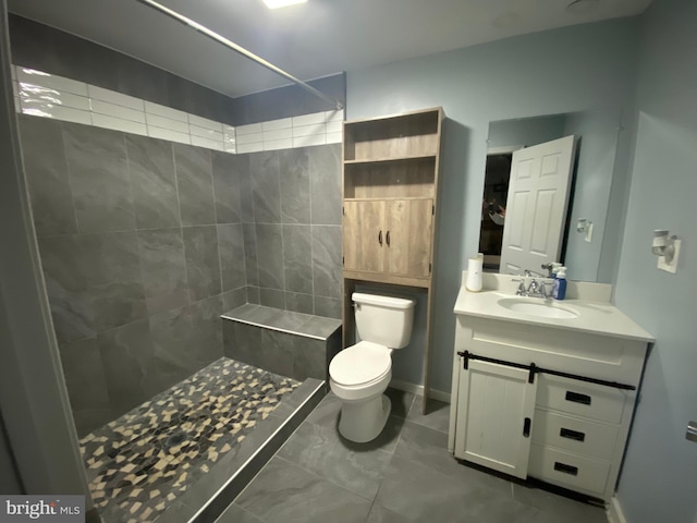 bathroom with vanity, toilet, and tiled shower