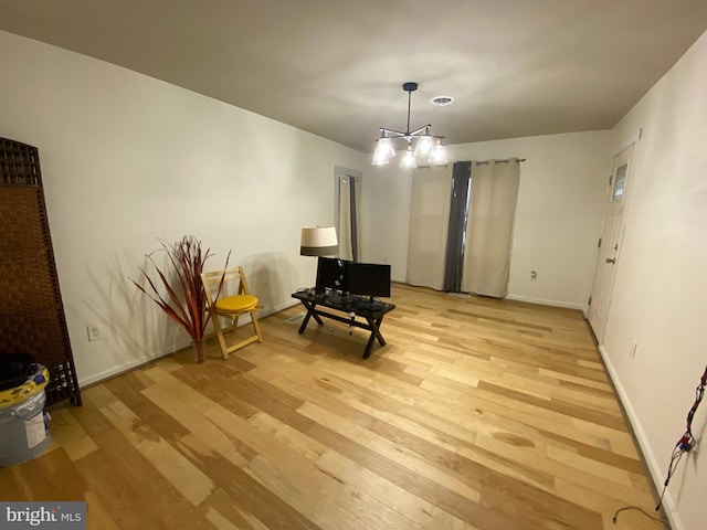 living area with light wood-type flooring and a notable chandelier