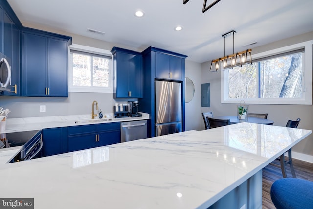 kitchen with a breakfast bar, a healthy amount of sunlight, sink, and stainless steel appliances