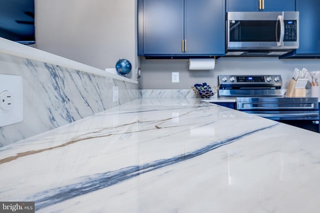 kitchen featuring stainless steel appliances and light stone counters